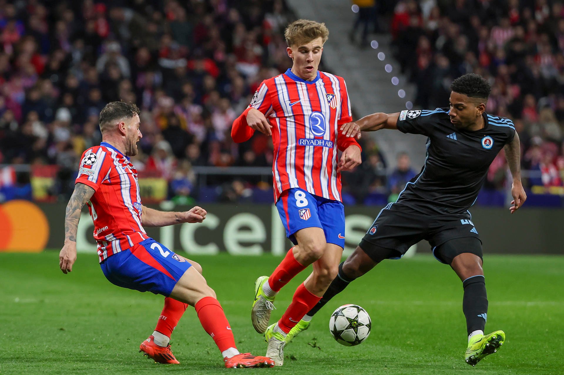 Los jugadores del Atlético de Madrid, Javi Galán (i) y Pablo Barrios, disputan un balón ante el centrocampista panameño del Sl. Bratislava, César Blackman. /EFE