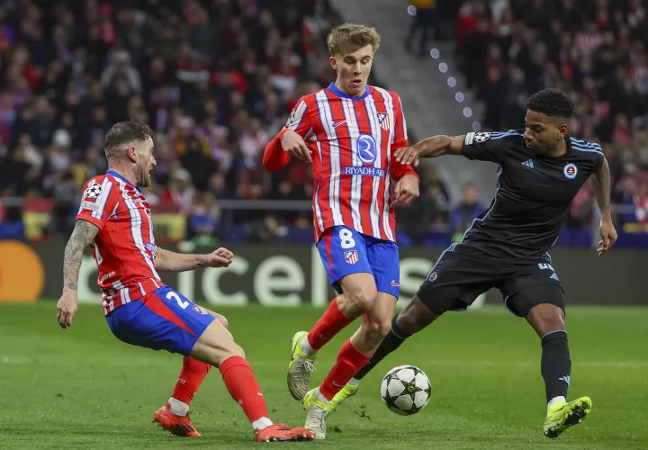 Los jugadores del Atlético de Madrid, Javi Galán (i) y Pablo Barrios, disputan un balón ante el centrocampista panameño del Sl. Bratislava, César Blackman. /EFE